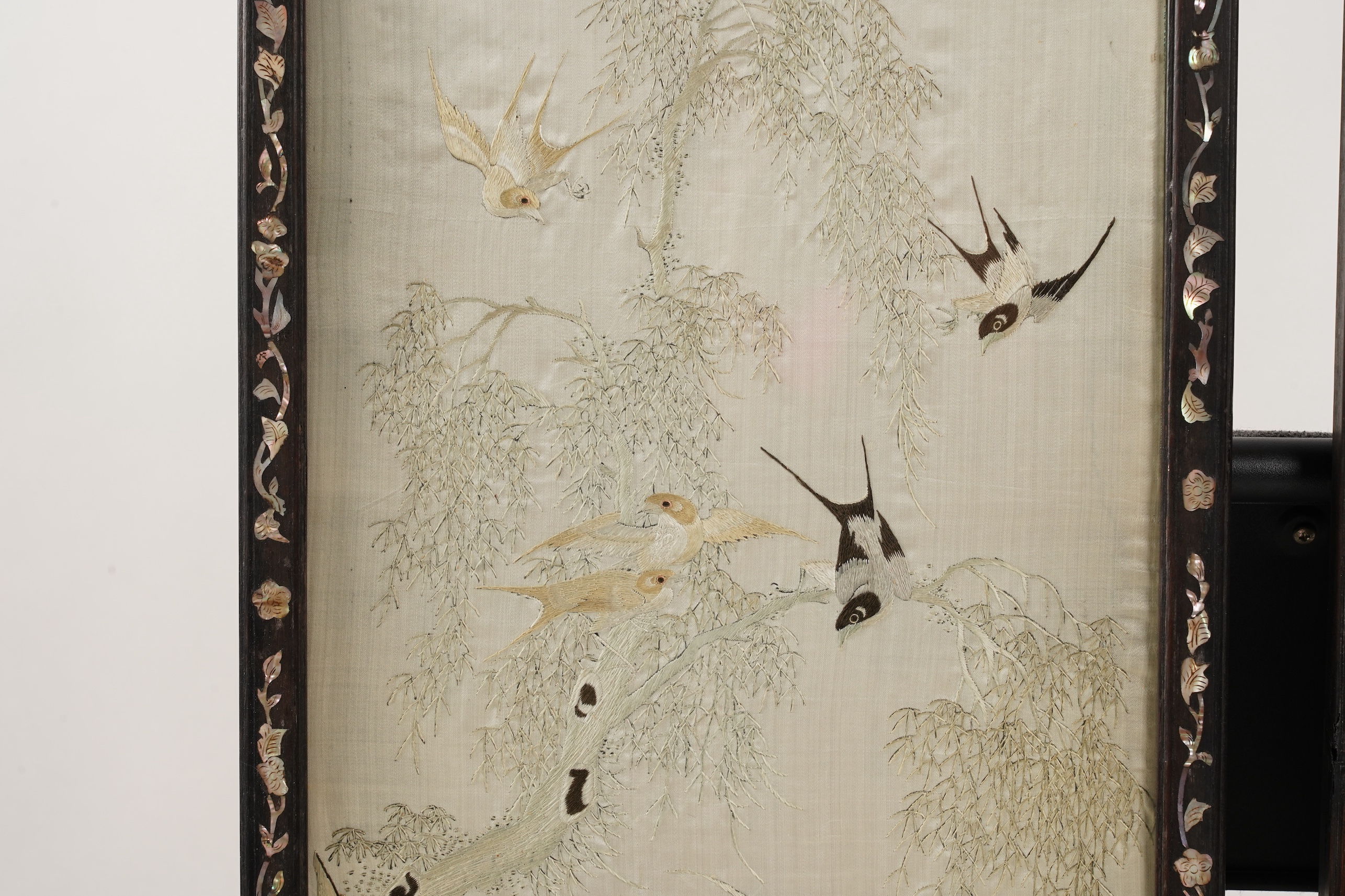 A pair of Chinese embroidered silk ‘bird’ panels, in mother-of-pearl inlaid hongmu frames, late 19th/early 20th century